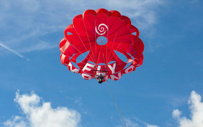 Parasailing adventure with red parachute in Albufeira sky.