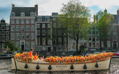 Guests enjoying a flower-adorned boat cruise on an Amsterdam canal.