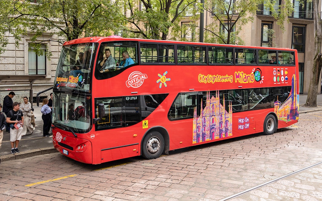City Sightseeing Milan hop-on hop-off bus at a passenger stop.