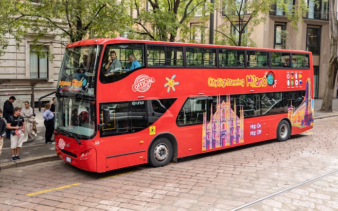 City Sightseeing Milan hop-on hop-off bus at a passenger stop.