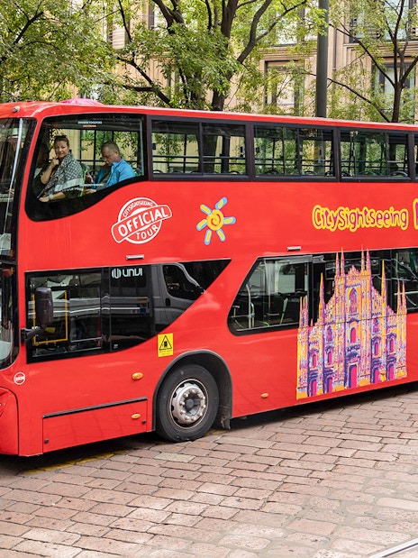 City Sightseeing Milan hop-on hop-off bus at a passenger stop.