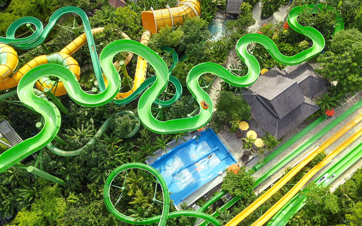 Aerial view of the Constrictor water slide at Waterbom Bali, surrounded by lush greenery.
