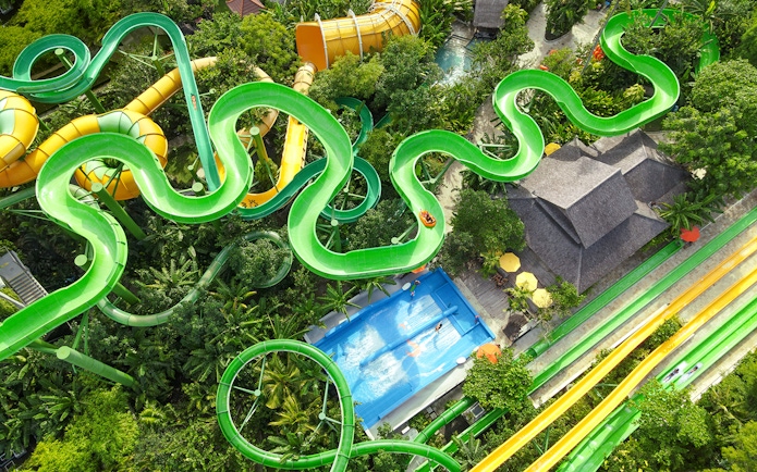 Aerial view of the Constrictor water slide at Waterbom Bali, surrounded by lush greenery.