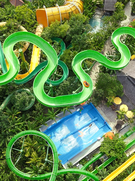 Aerial view of the Constrictor water slide at Waterbom Bali, surrounded by lush greenery.