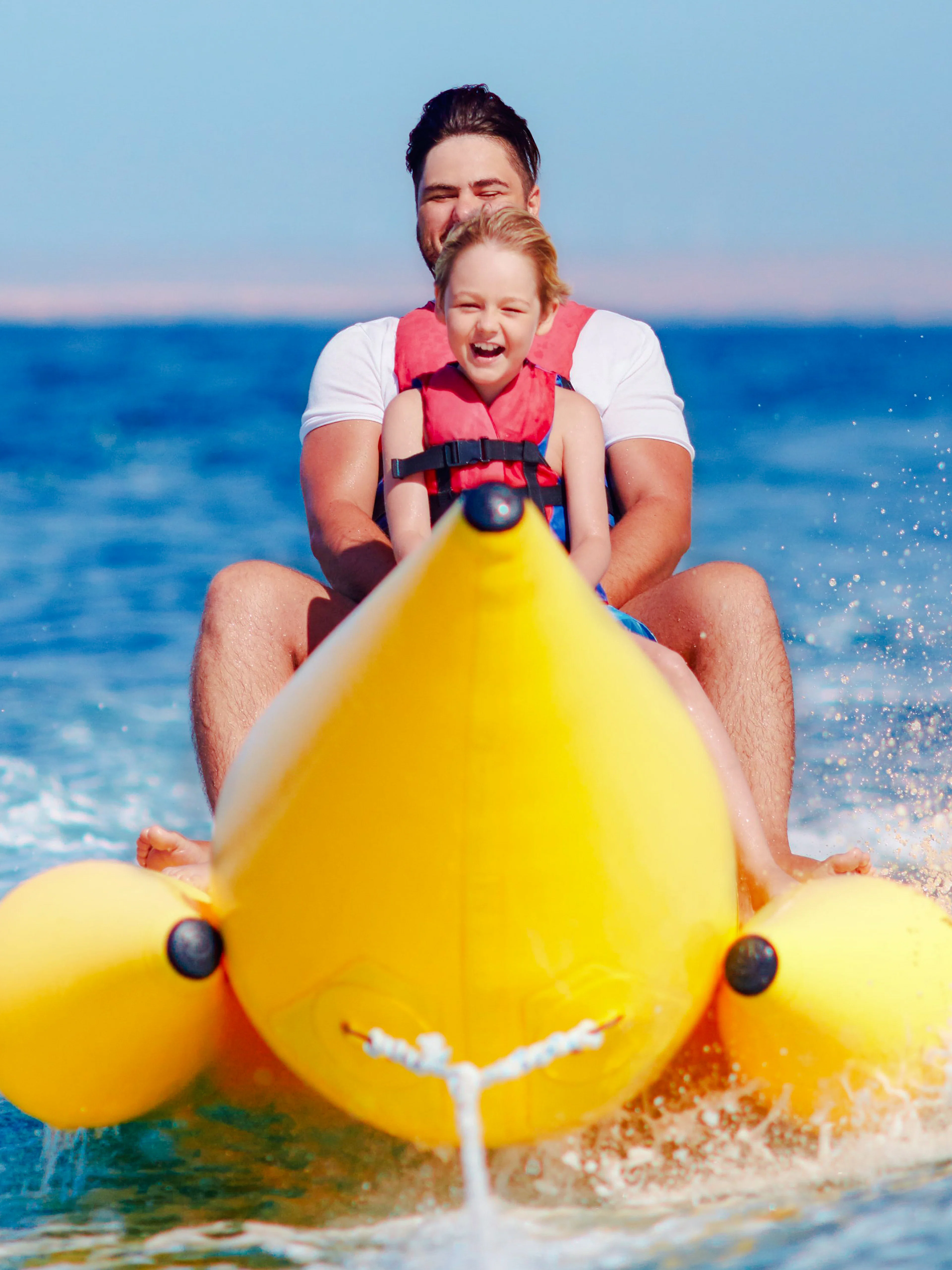 Family riding a banana boat on the sea in Dubai.