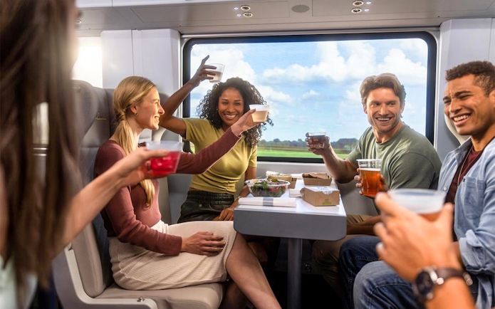 Group enjoying drinks on a train during Miami trip with open top bus and islands boat cruise.