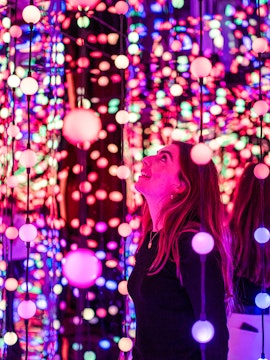 Visitor enjoying colorful light installation at Dopamine Land.