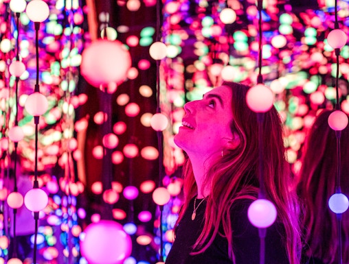 Visitor enjoying colorful light installation at Dopamine Land.