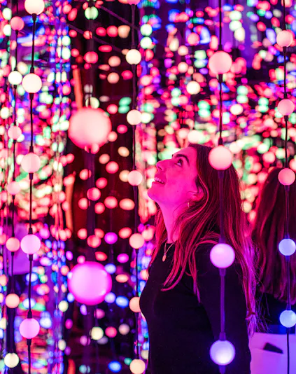 Visitor enjoying colorful light installation at Dopamine Land.