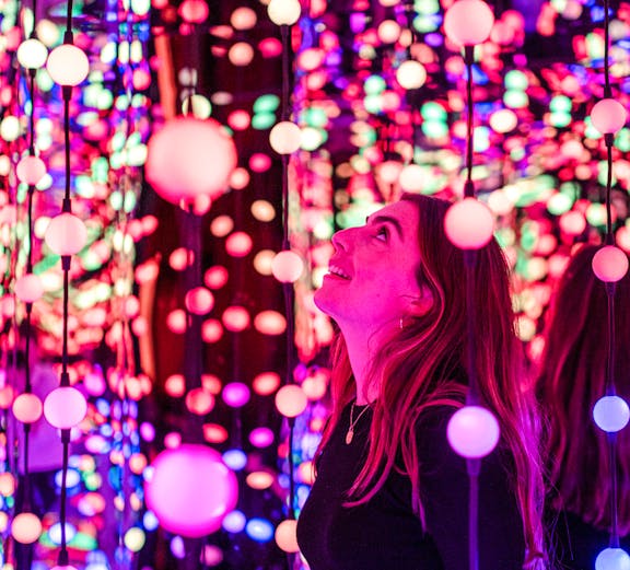 Visitor enjoying colorful light installation at Dopamine Land.
