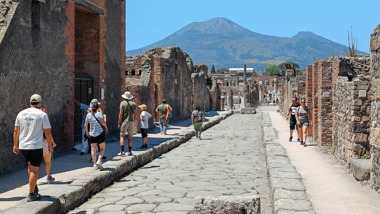 Visitors exploring ancient ruins in Pompeii on a day trip from Rome.