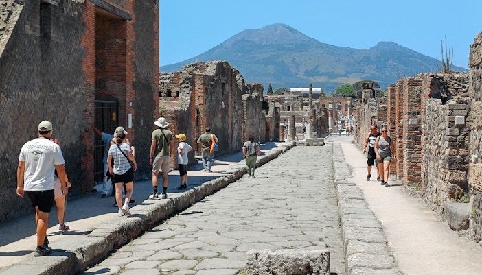 Visitors exploring ancient ruins in Pompeii on a day trip from Rome.