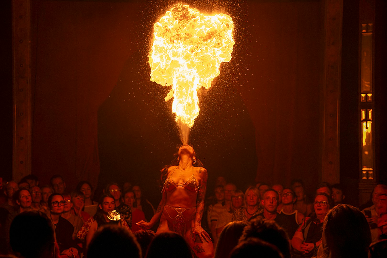 Performer breathing fire on stage at La Clique show.