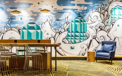 Plaza Premium Lounge seating area with artistic mural at Rio de Janeiro Airport, T2.