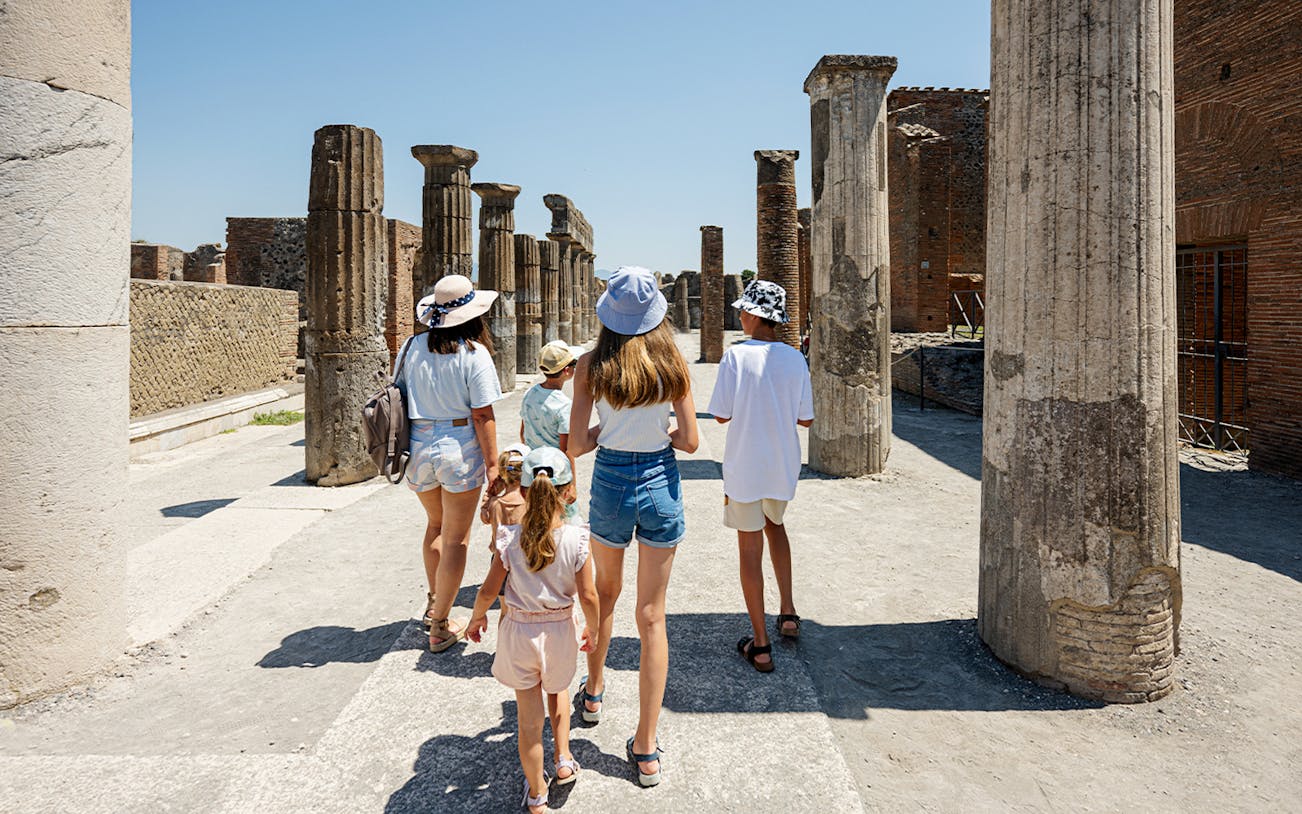 Tourists exploring ancient ruins in Pompeii, Italy.