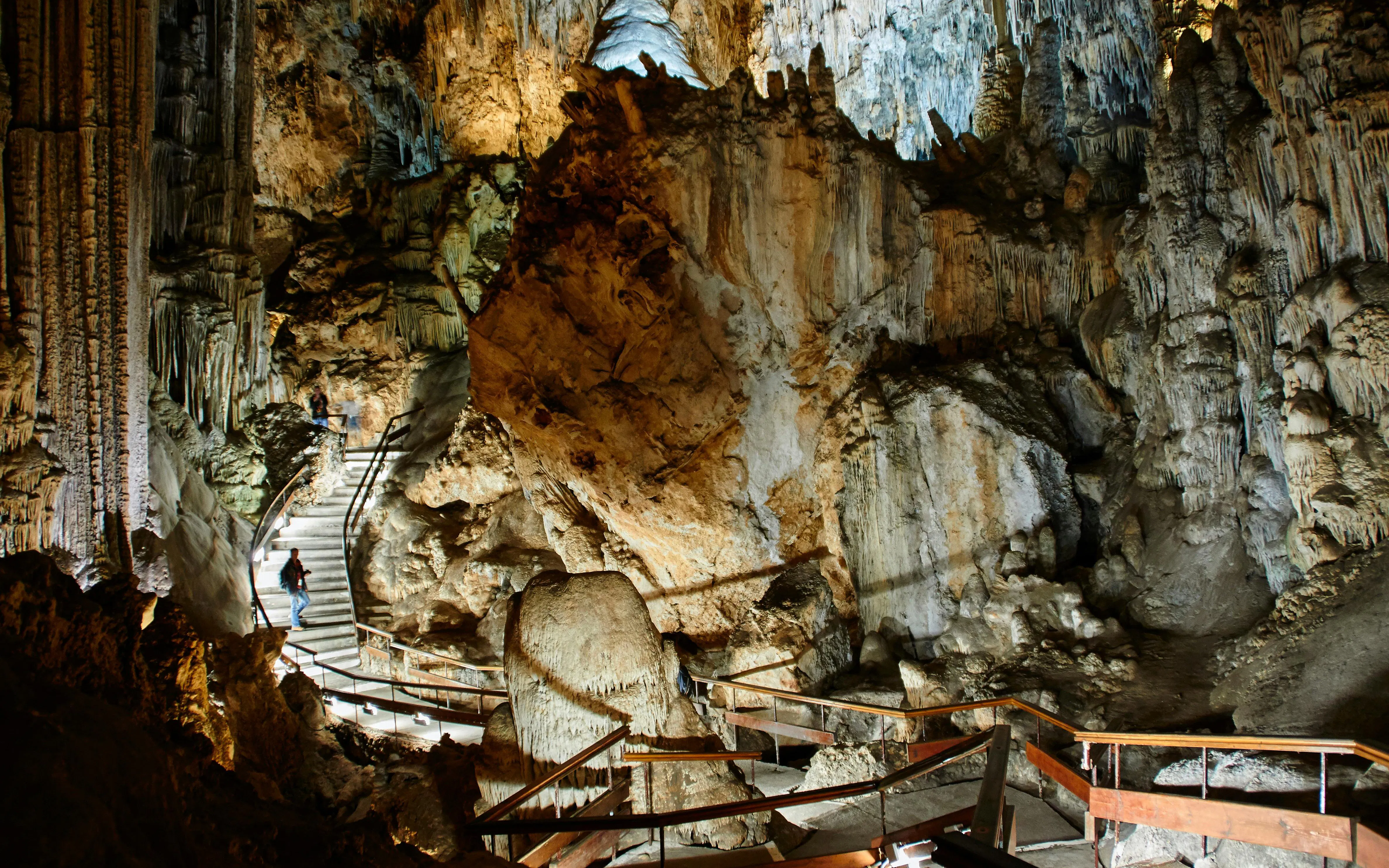 Visitors exploring the illuminated stalactites and stalagmites in the Caves of Nerja, Spain.