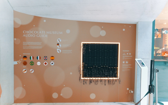 Audio guide station at Lindt Chocolate Museum with multiple language options.