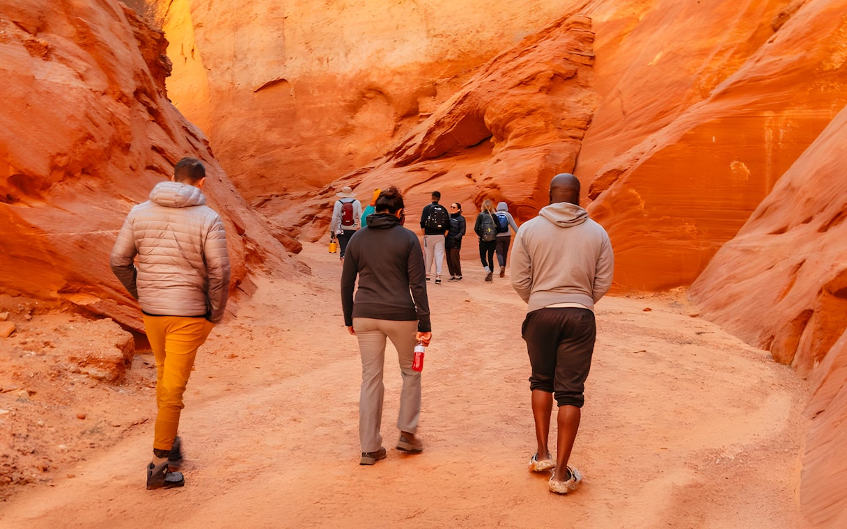 Tourists walking through the narrow, red rock formations of Antelope Canyon.