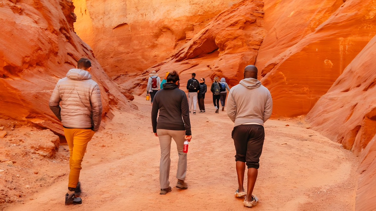 Tourists walking through the narrow, red rock formations of Antelope Canyon.