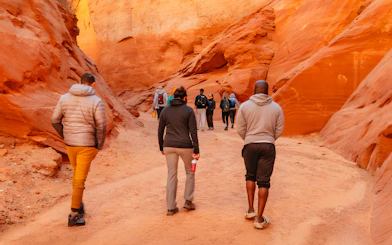 Tourists walking through the narrow, red rock formations of Antelope Canyon.