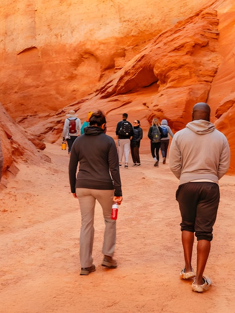 Tourists walking through the narrow, red rock formations of Antelope Canyon.