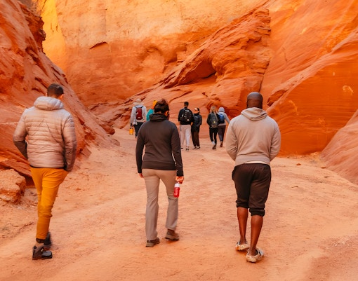 Tourists walking through the narrow, red rock formations of Antelope Canyon.