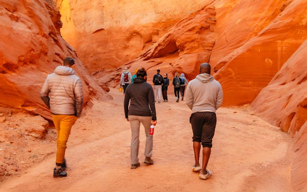 Tourists walking through the narrow, red rock formations of Antelope Canyon.