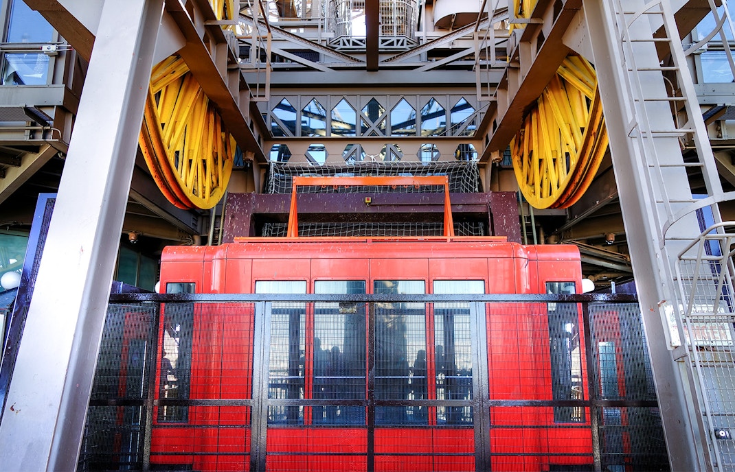 Ein gelber Aufzug fährt am Eiffelturm nach oben