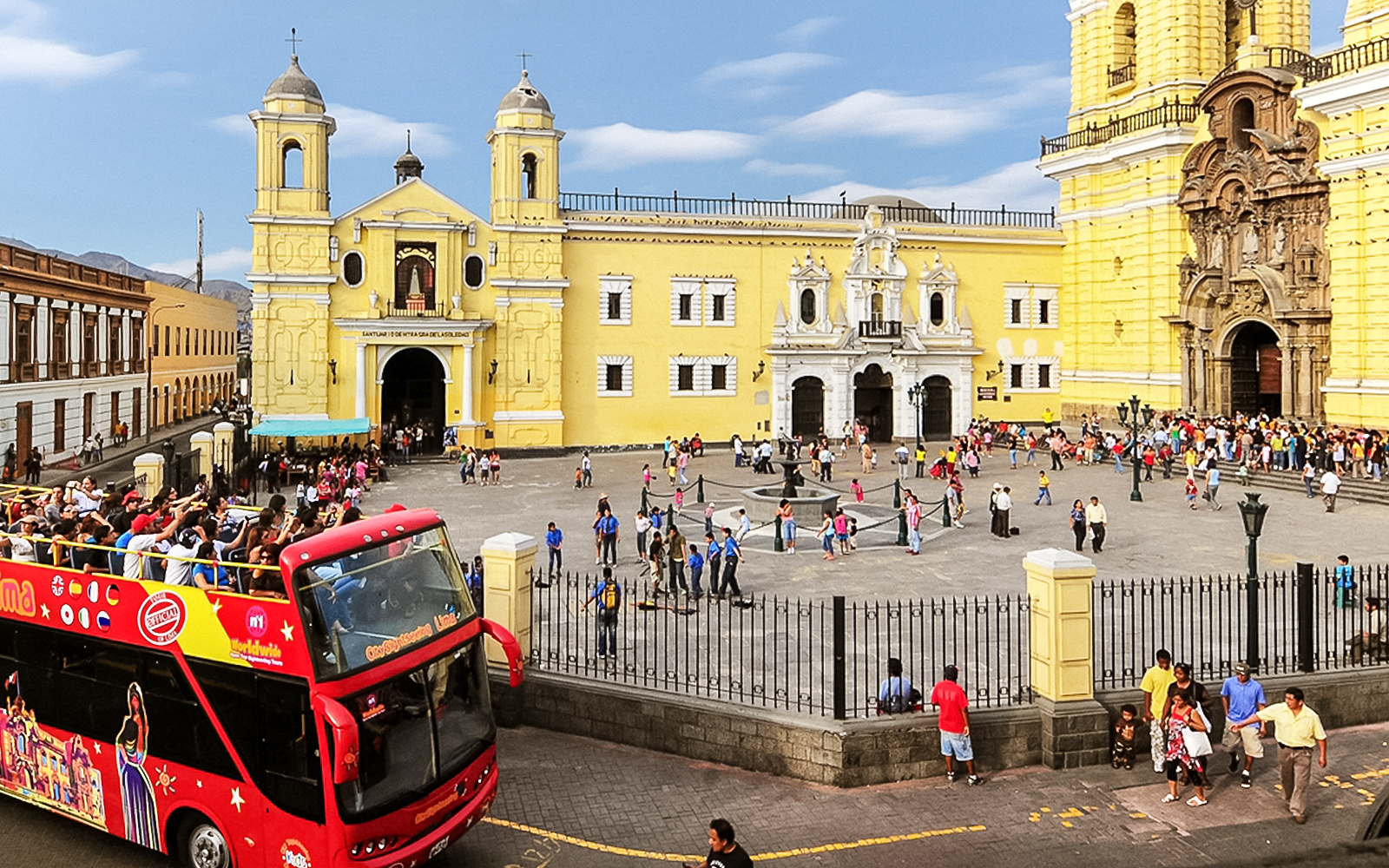 Tourists enjoying a Bus Tour of Peru, exploring the vibrant city of Lima with a hop-on-hop-off bus service