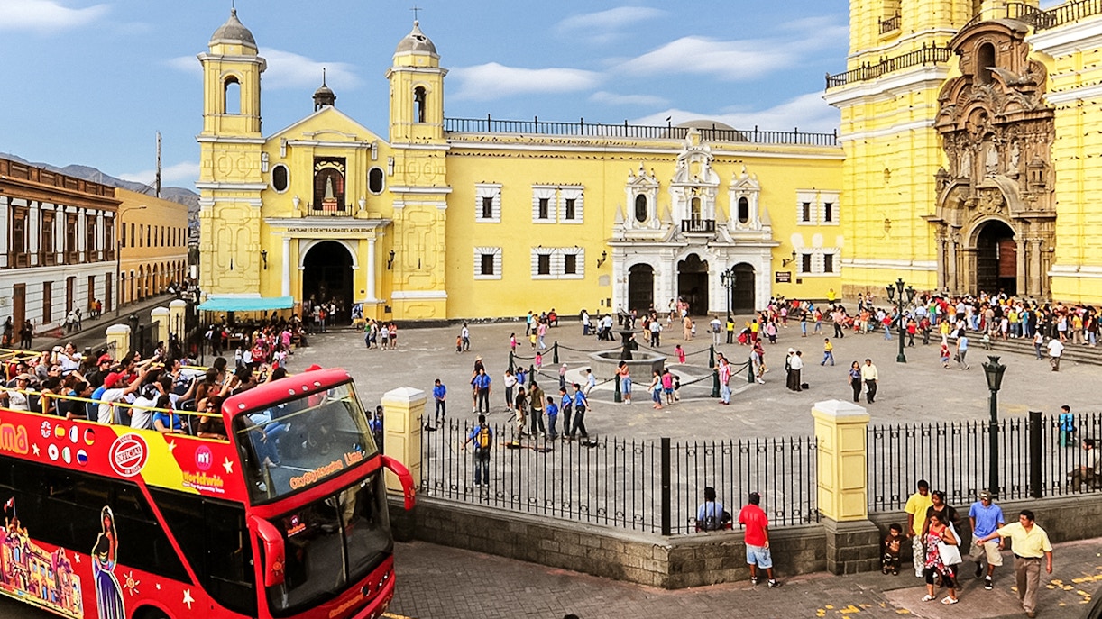 Tourists enjoying a Bus Tour of Peru, exploring the vibrant city of Lima with a hop-on-hop-off bus service