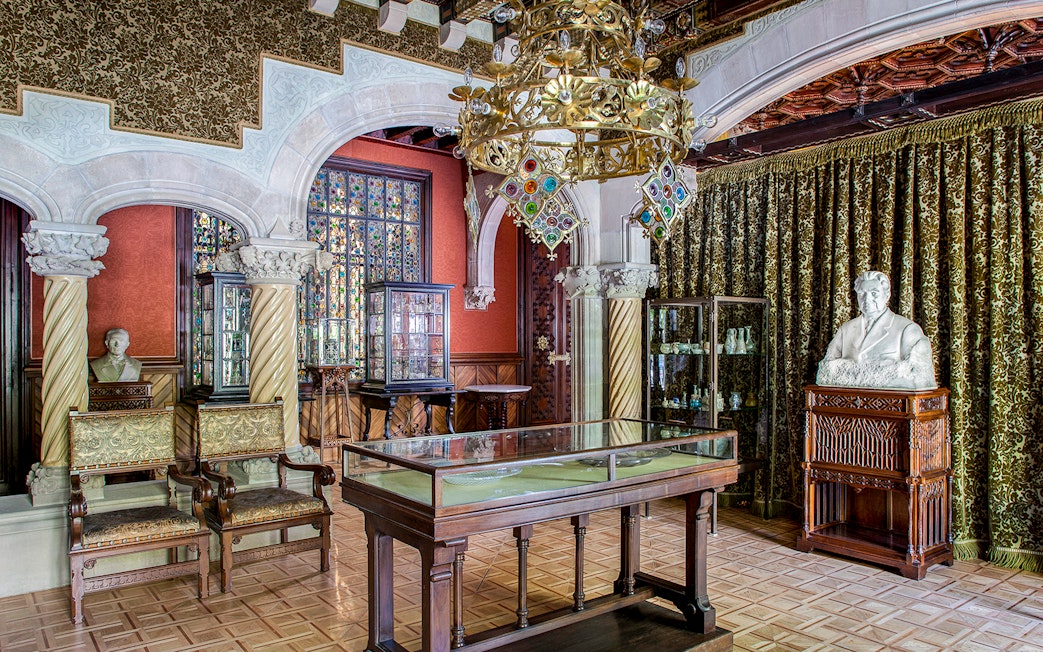 Casa Amatller interior with ornate chandelier, stained glass, and sculptures.