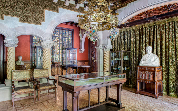 Casa Amatller interior with ornate chandelier, stained glass, and sculptures.