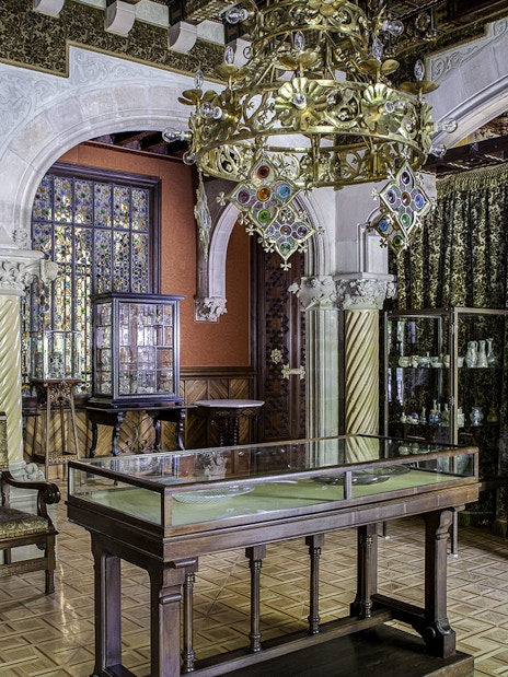 Casa Amatller interior with ornate chandelier, stained glass, and sculptures.