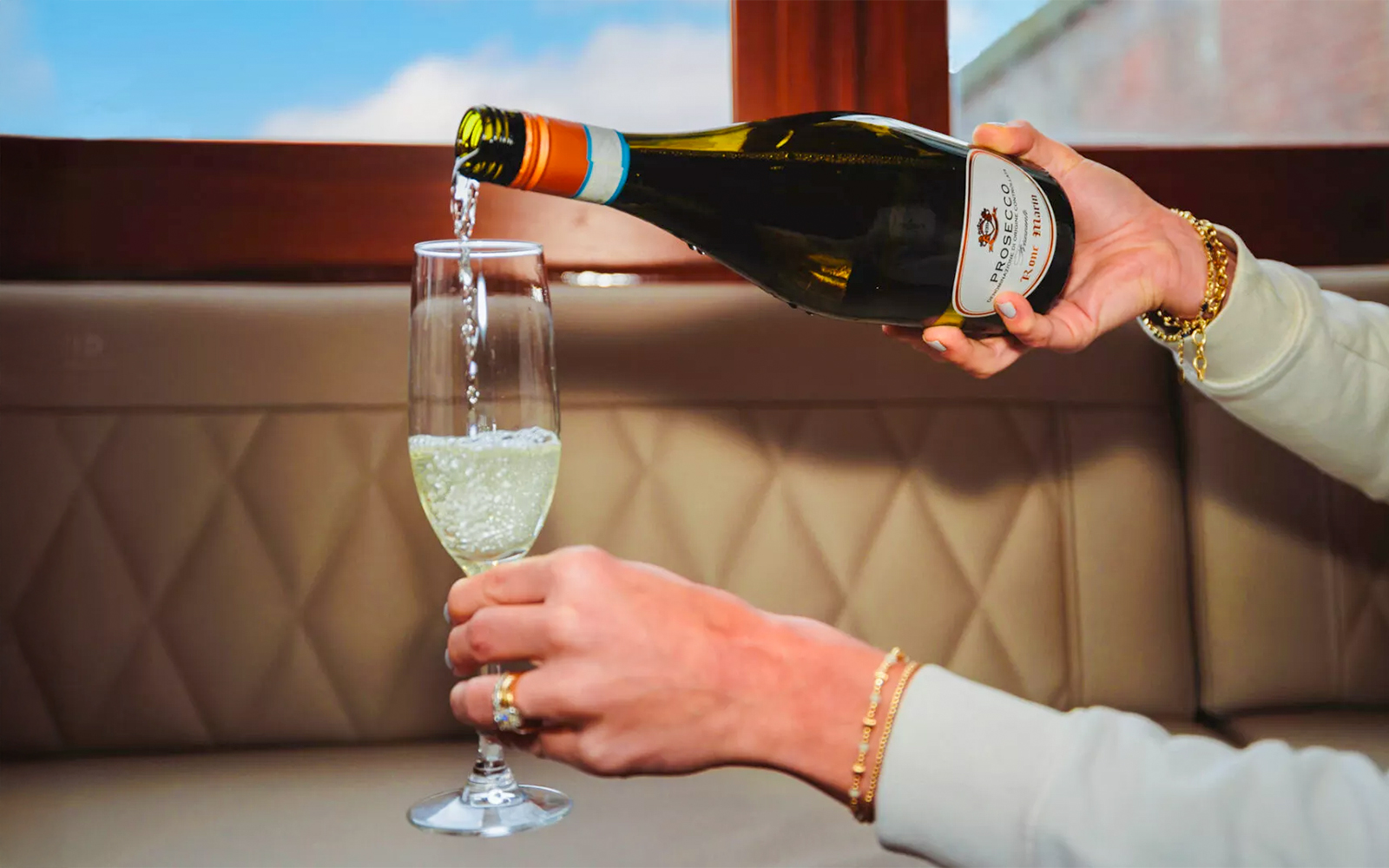 Pouring wine into a glass on a luxury romantic cruise in Amsterdam.