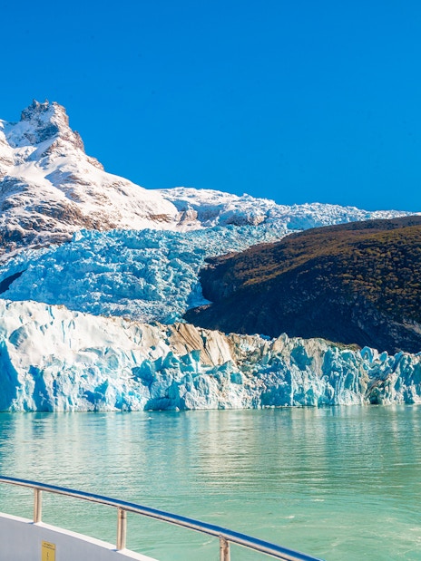 Boat approaching Spegazzini Glacier with snow-capped mountains in Los Glaciares National Park, Argentina.