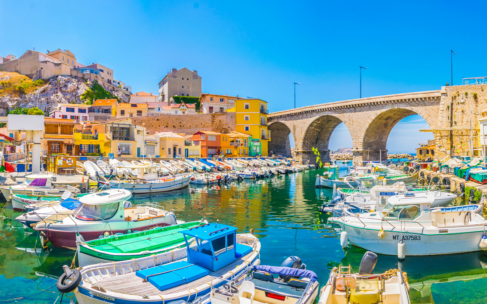Vallon des Auffes port with colorful boats and traditional houses in Marseille, France.