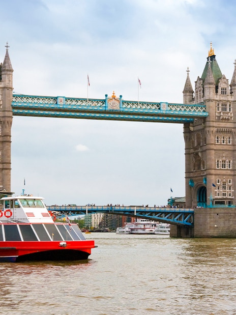River cruise boat passing under Tower Bridge, London.