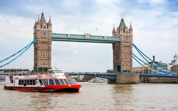 River cruise boat passing under Tower Bridge, London.