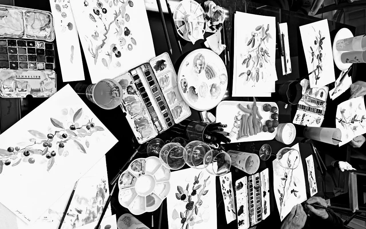 Barcelona art night with paint supplies, canvases, and drinks on a table.