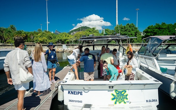 Tourists boarding a cruise boat at a marina in Rio de Janeiro.