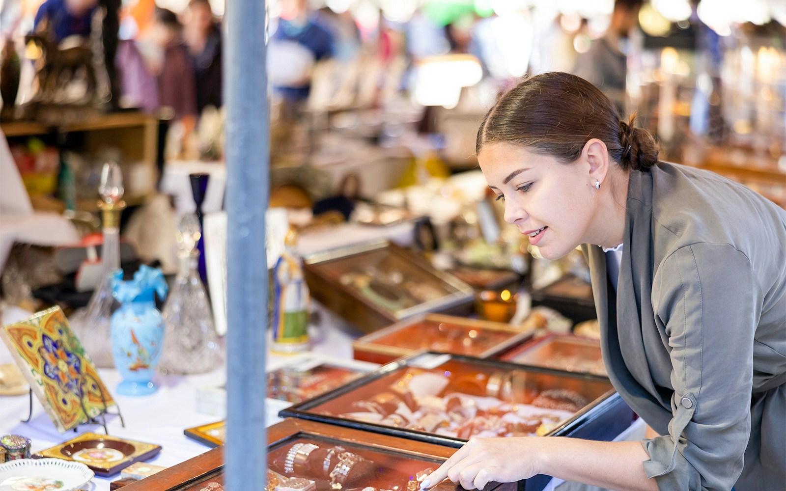 Woman browsing antiques at a market in Las Golondrinas, Barcelona.