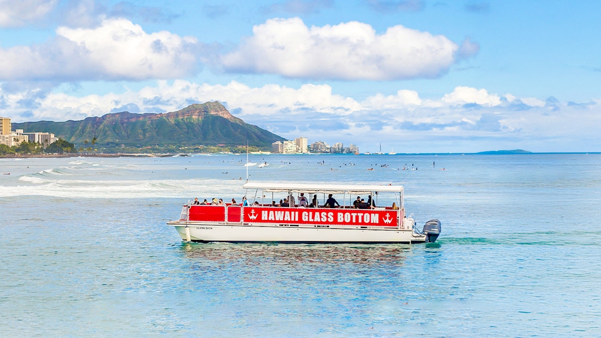 Glass-bottom boat on Waikiki coast with Diamond Head in background, Hawaii tour.