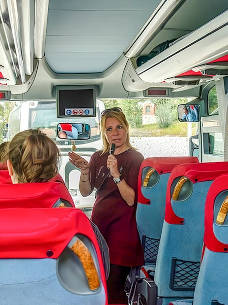Tour guide speaking to guests on a bus during Ancient Mycenae & Nafplion Premium Tour.