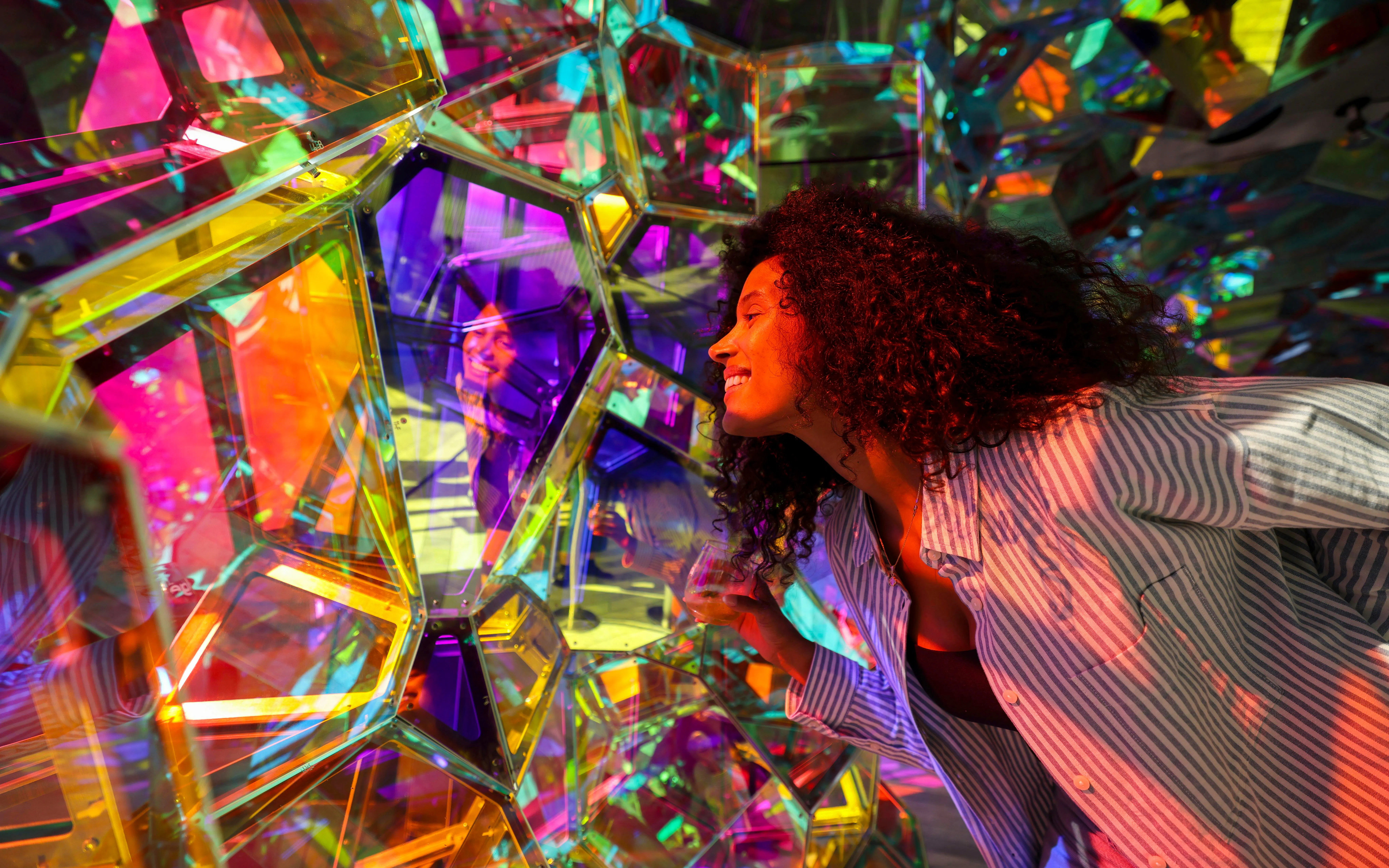 Person exploring colorful kaleidoscope installation at Edge Observatory, New York.