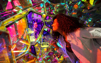 Person exploring colorful kaleidoscope installation at Edge Observatory, New York.