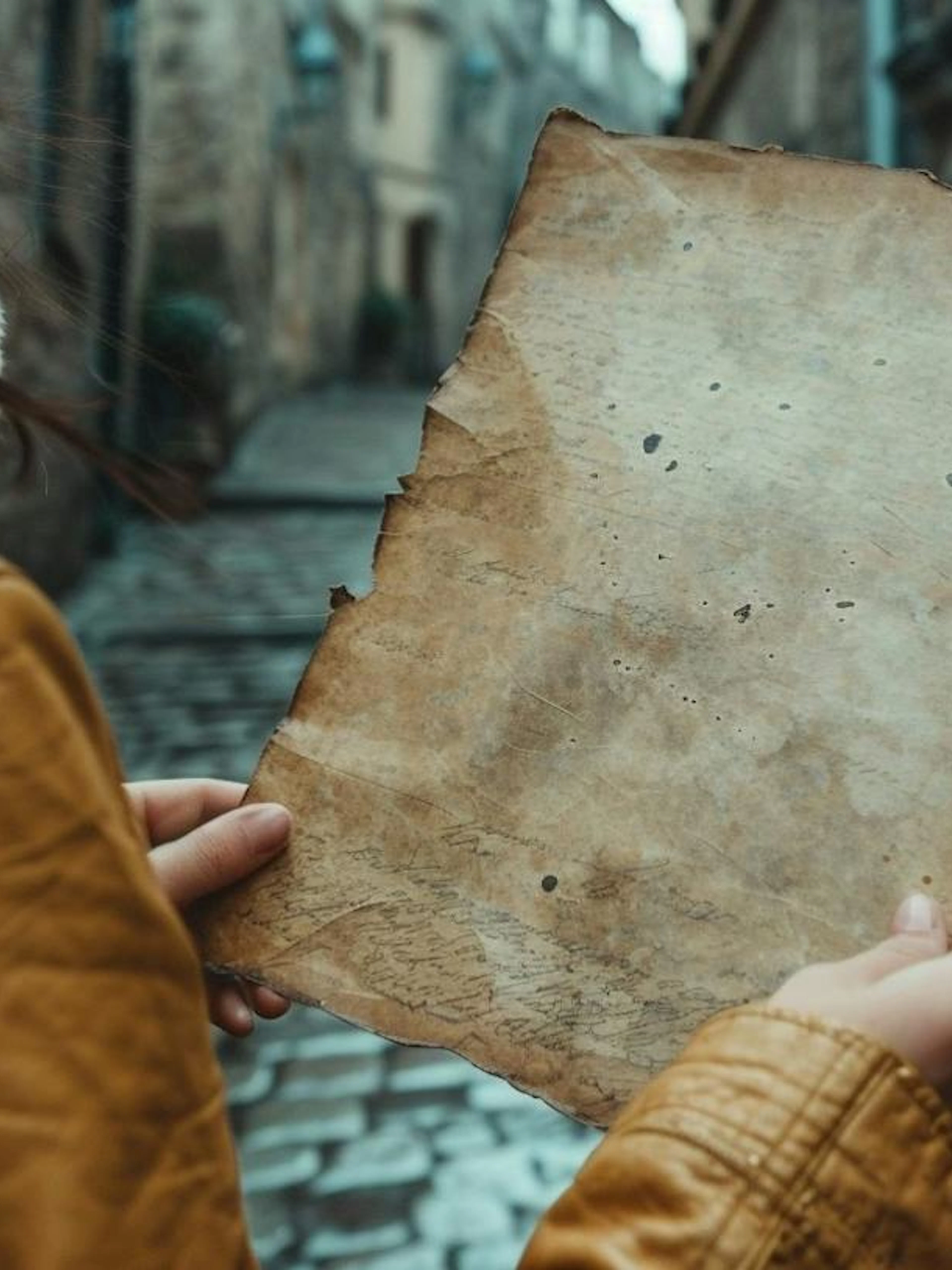 Person holding an old map on a cobblestone street in Bucharest.