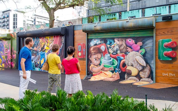 Visitors admiring colorful murals at Wynwood Walls Museum in Miami.