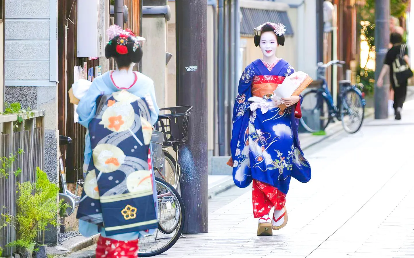 Geisha in traditional attire walking through the streets of Kyoto.
