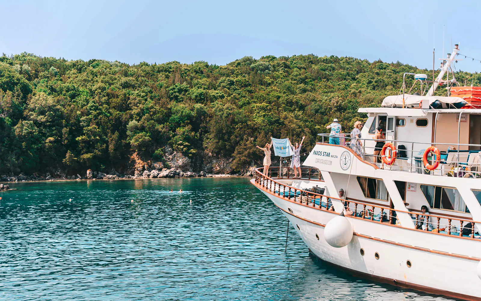 Cruise boat near lush coastline on Blue Lagoon & Papanikolis tour from Benitses/Lefkimmi.