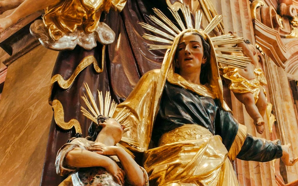 Statue of a woman and child with golden halos inside St Anne's Church.